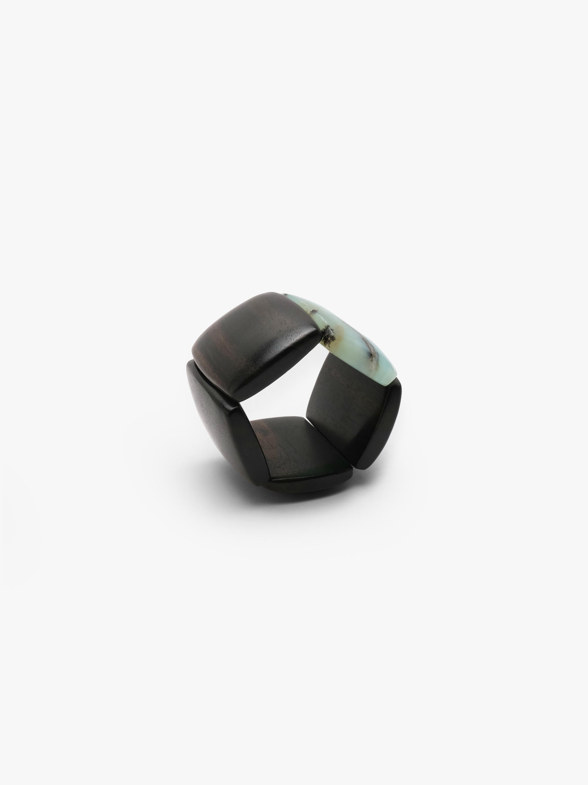 A bracelet made from black and light blue stone squares, displayed on a white background