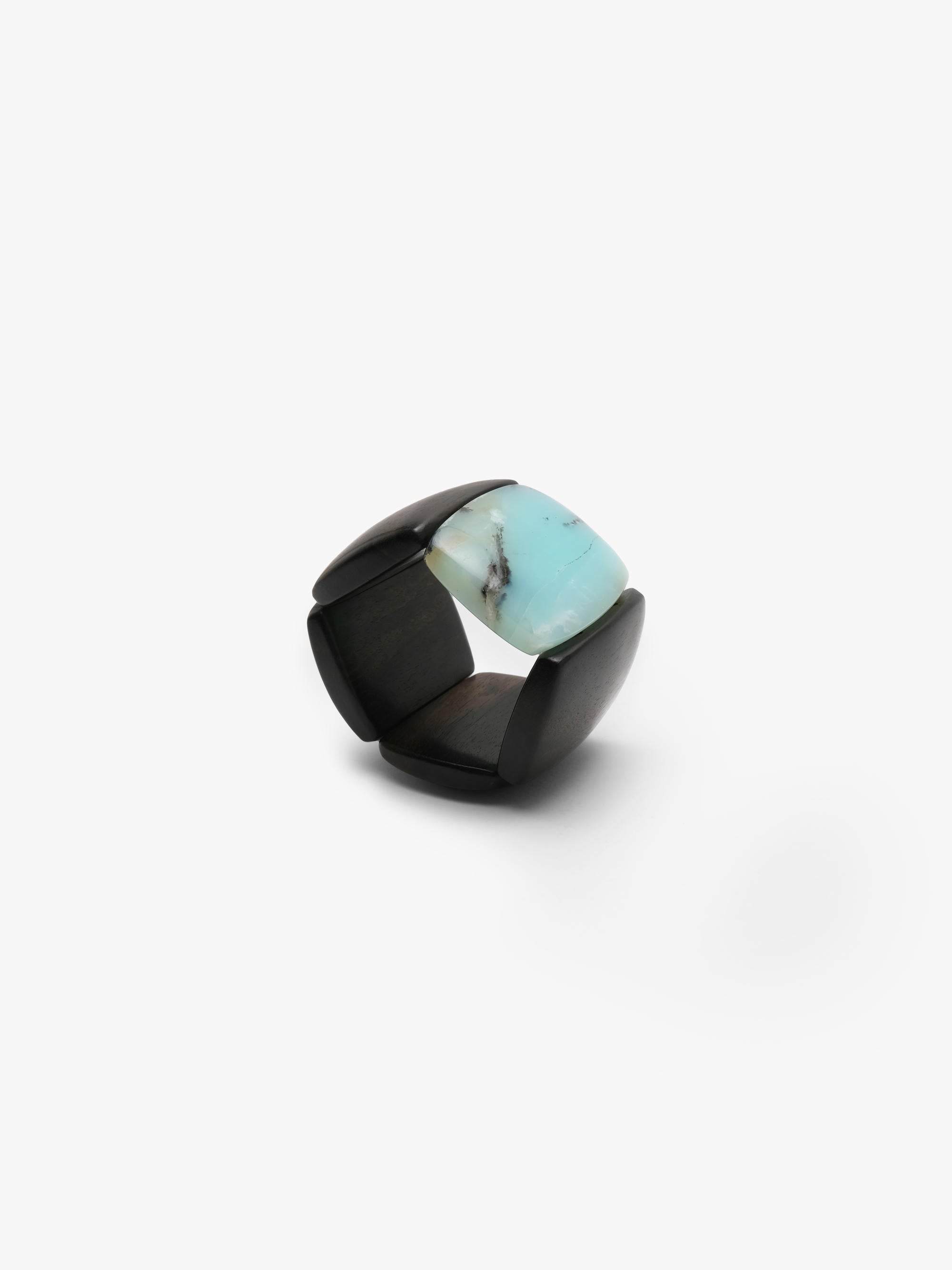 A bracelet made from black and light blue stone squares, displayed on a white background