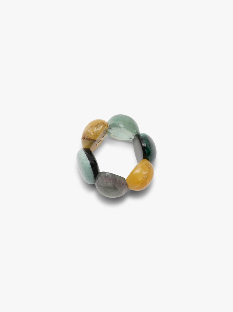 A bracelet of five polished teardrop-shaped gemstone pendants in various colors including yellow, green, gray, and black, arranged on a plain light gray background.