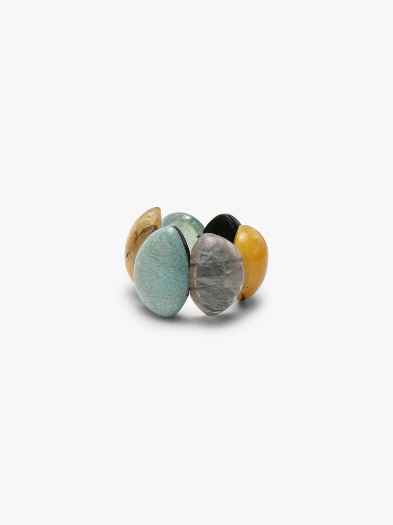 A bracelet of five polished teardrop-shaped gemstone pendants in various colors including yellow, green, gray, and black, arranged on a plain light gray background.