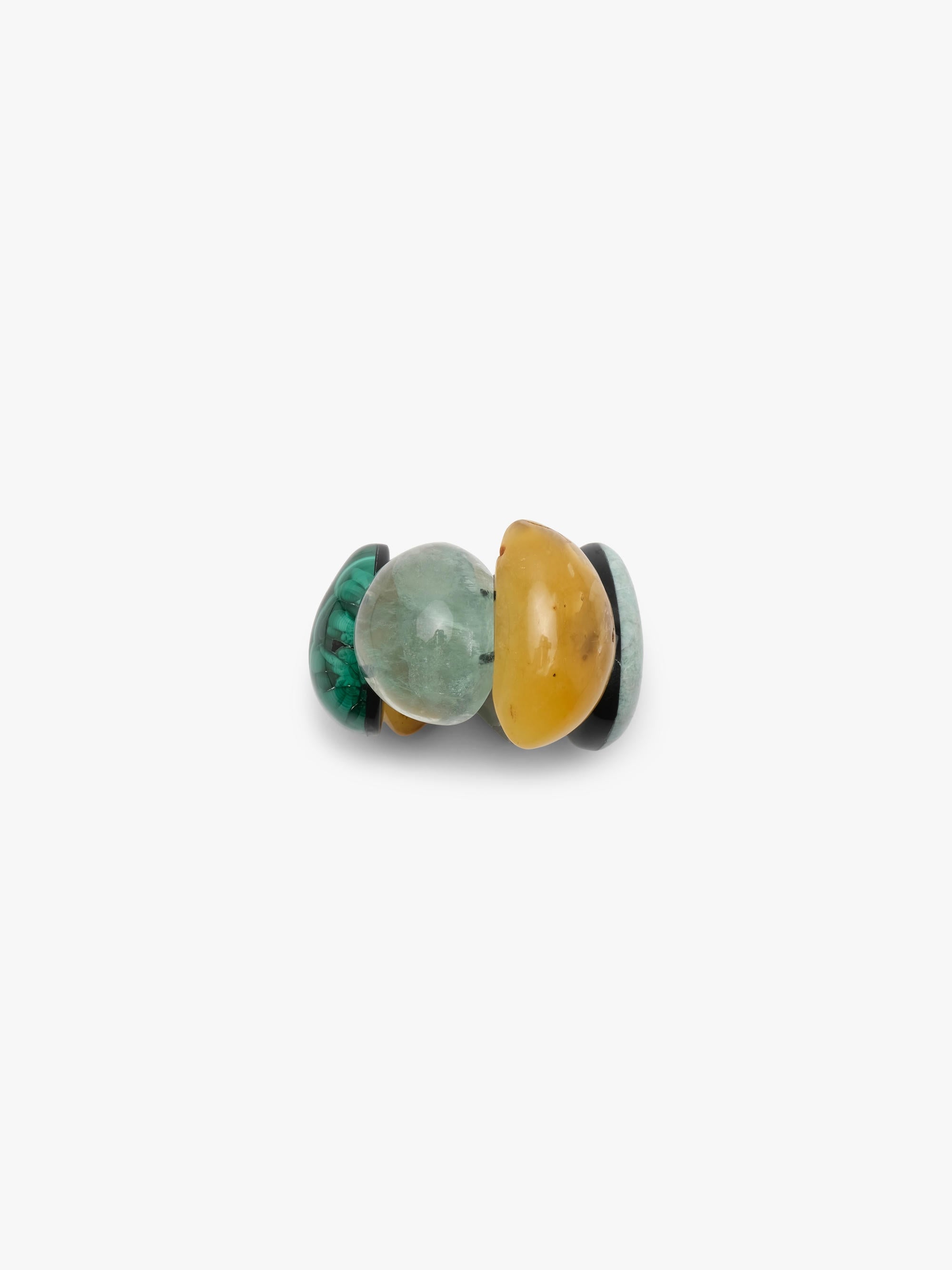 A bracelet of five polished teardrop-shaped gemstone pendants in various colors including yellow, green, gray, and black, arranged on a plain light gray background.