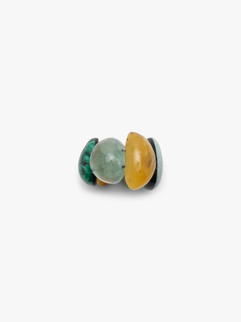 A bracelet of five polished teardrop-shaped gemstone pendants in various colors including yellow, green, gray, and black, arranged on a plain light gray background.