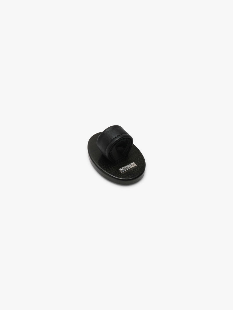 A ring with a patterened black and brown stone , shown against a solid off-white background.