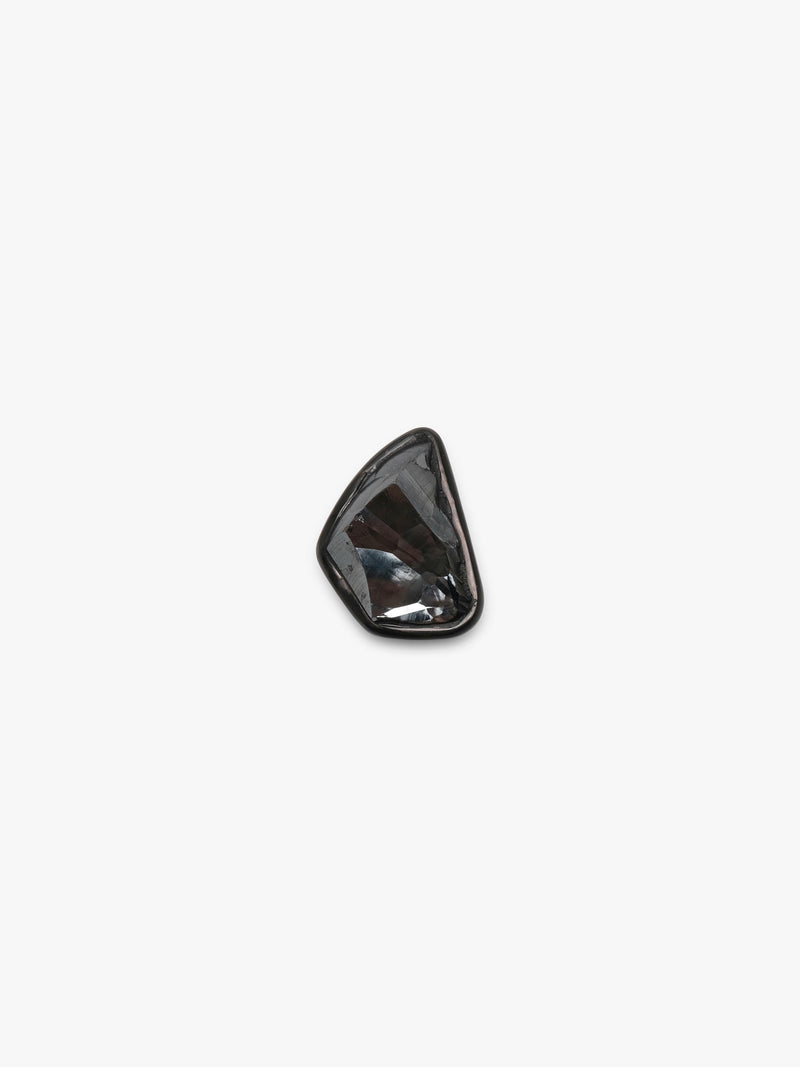 A black textured metallic stone ring set into a black piece of horn, displayed on a white background. 