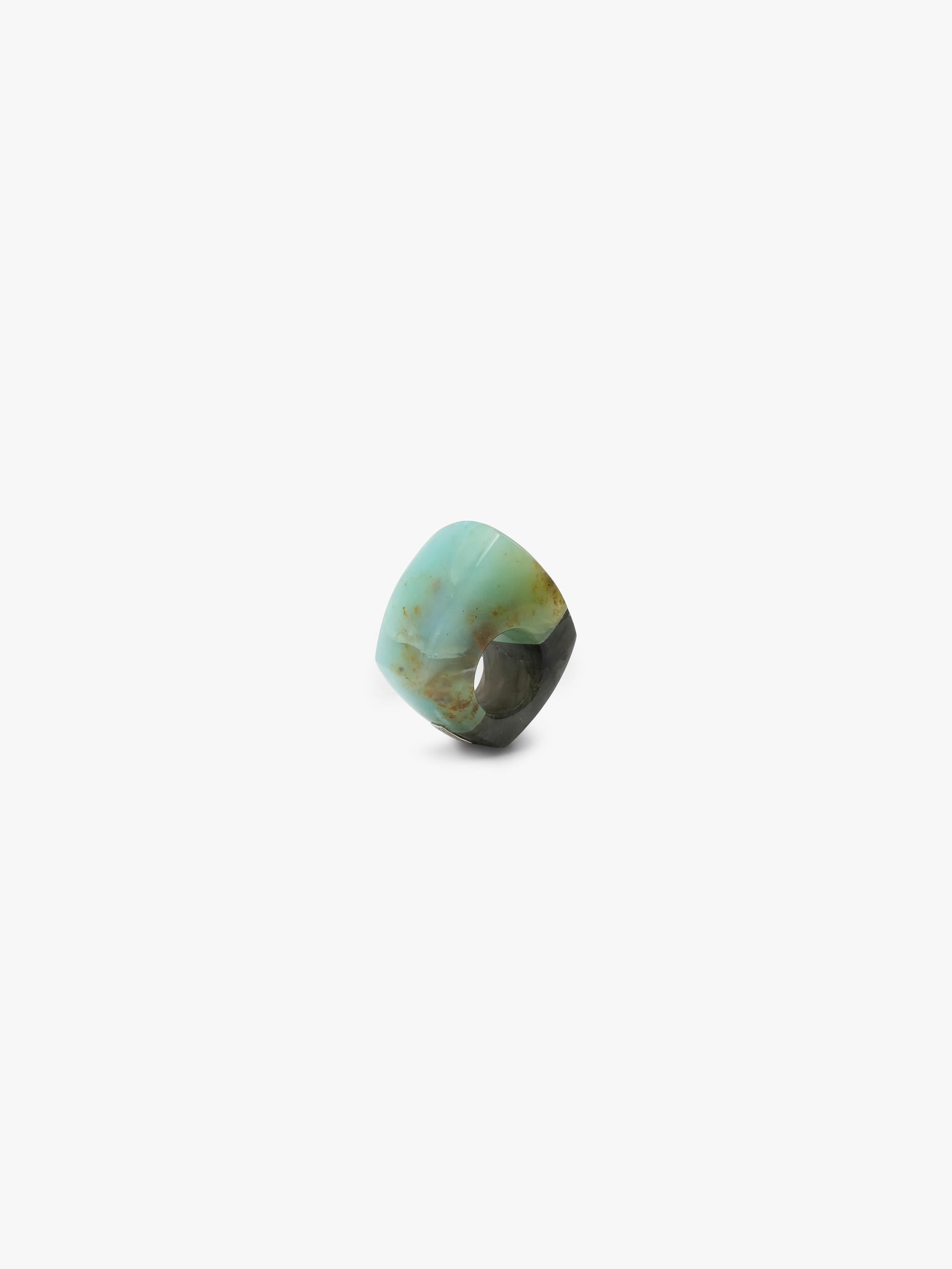 A single polished cabochon ring with a marbled pattern of light turquoise, olive green, and dark brown, shown on a plain light gray background.