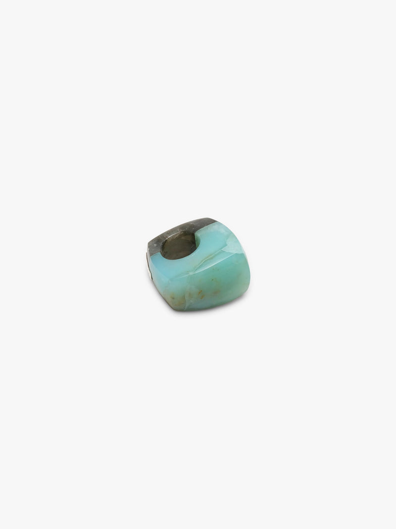 A single polished cabochon ring with a marbled pattern of light turquoise, olive green, and dark brown, shown on a plain light gray background.
