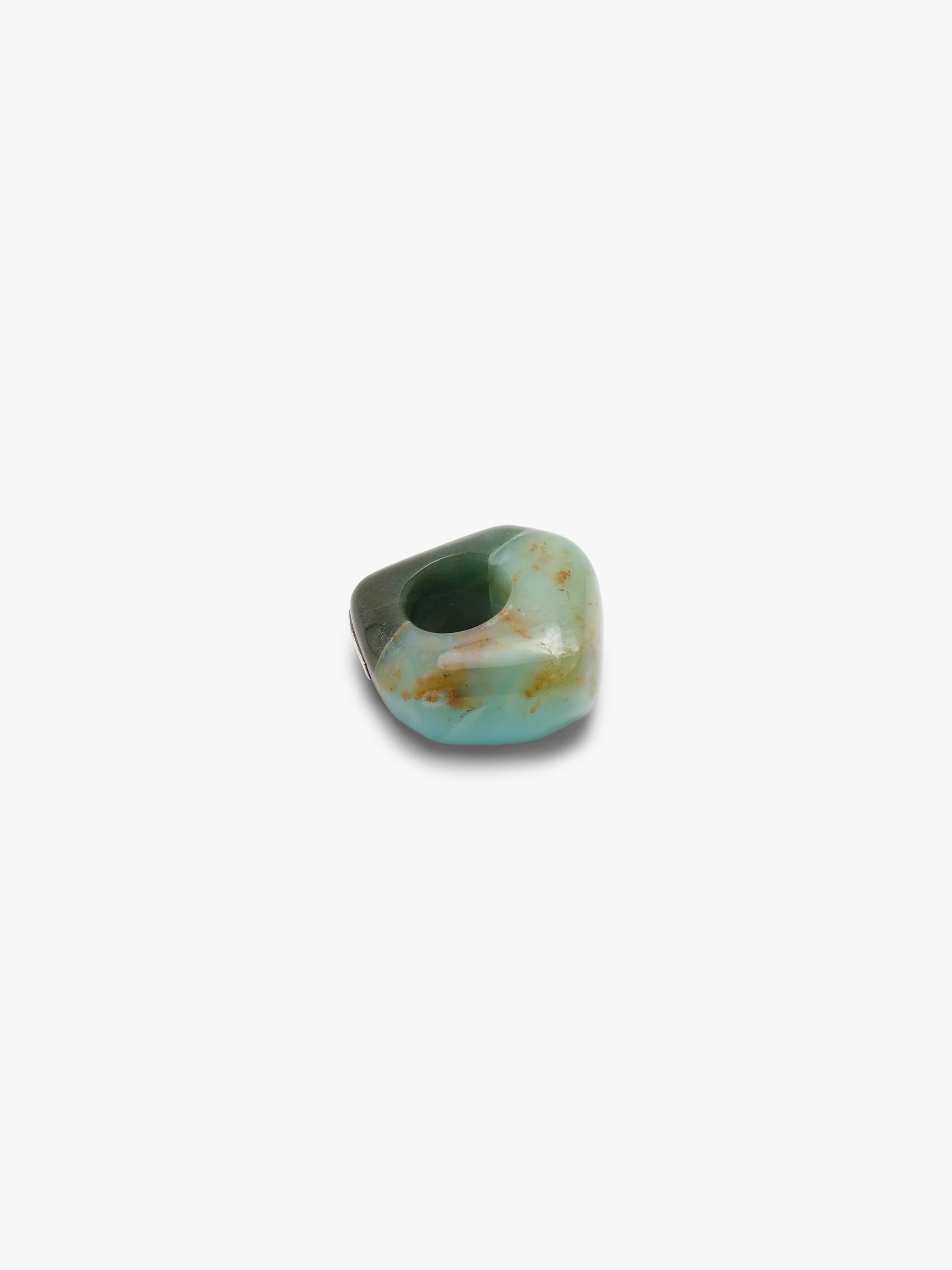 A , polished turquoise- and dark green colored stone ring with natural brown matrix inclusions, centered on a plain white background.
