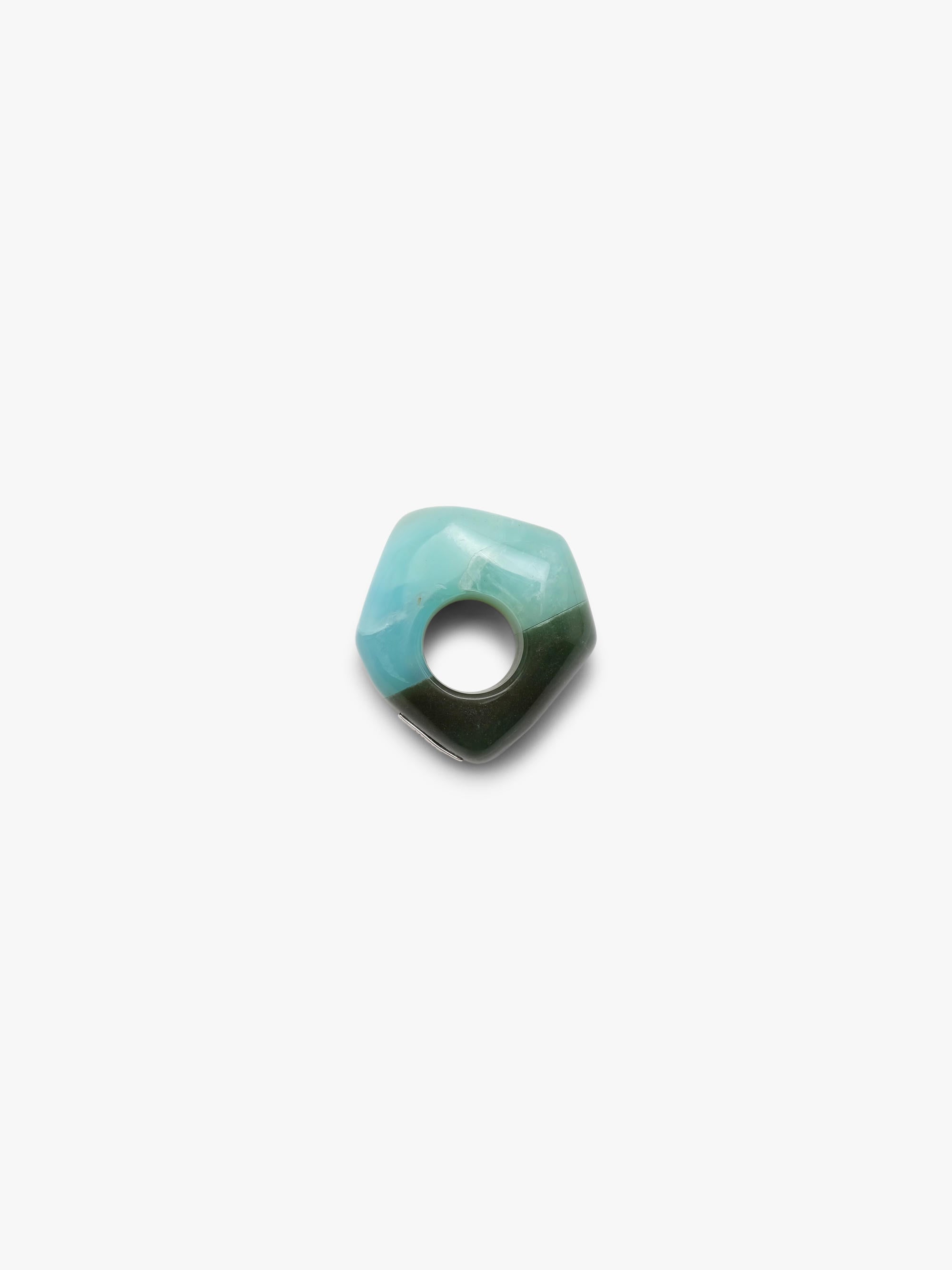 A , polished turquoise- and dark green colored stone ring with natural brown matrix inclusions, centered on a plain white background.