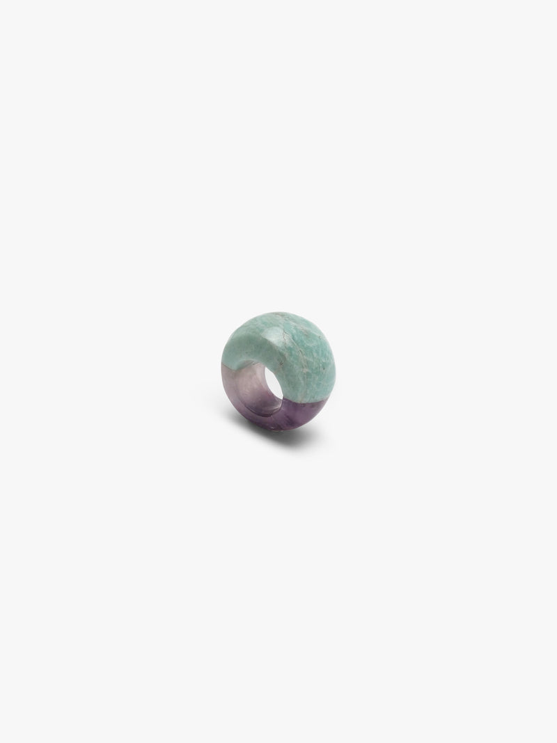 A curved ring mixing a light blue marble-looking stone wth a light purple stone, displayed on a white background.