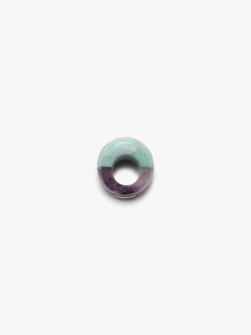 A curved ring mixing a light blue marble-looking stone wth a light purple stone, displayed on a white background.