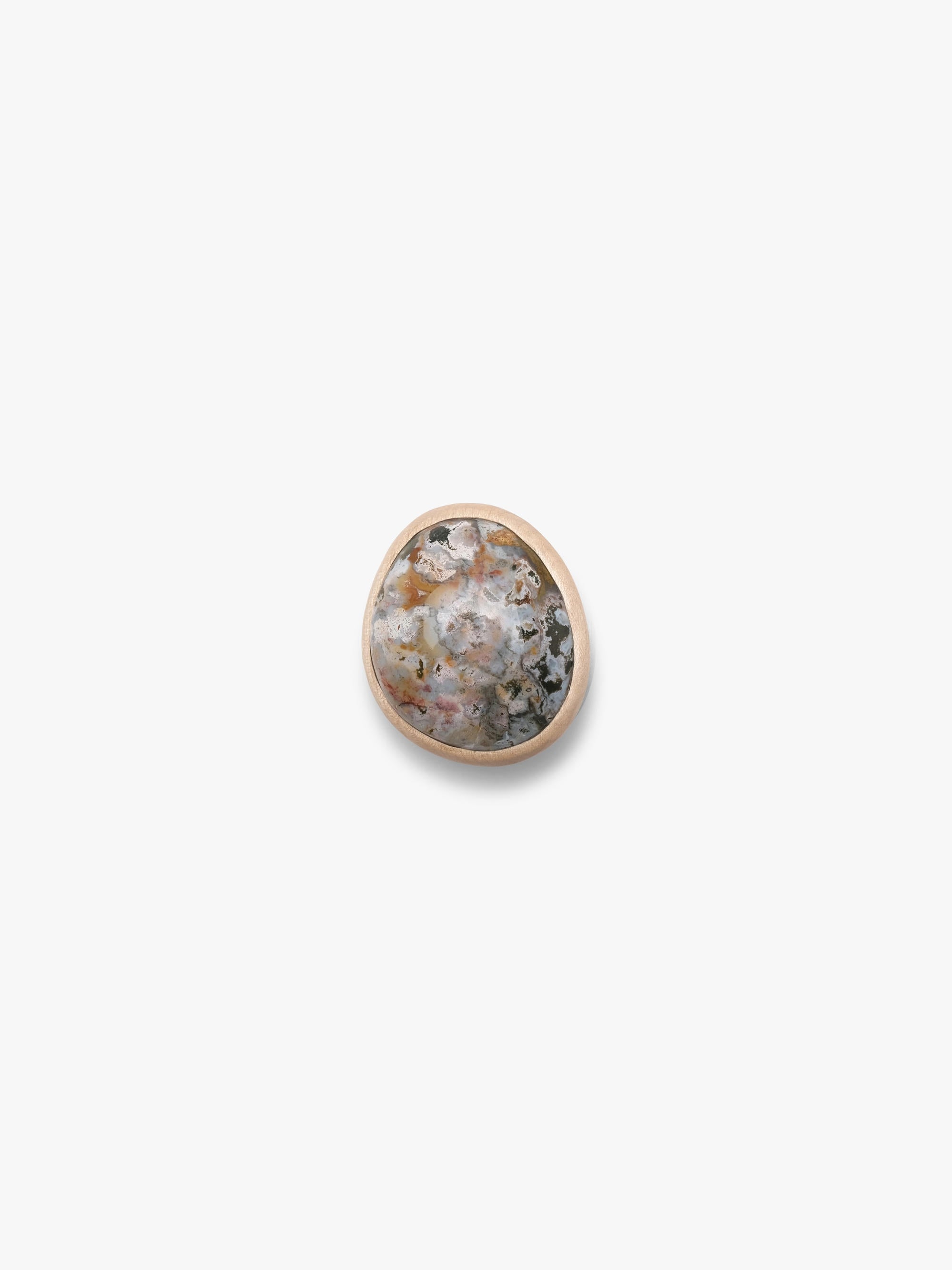 A large ring, with a marble stone top set into a light wood, with a light colored leather band. Displayed on a white background