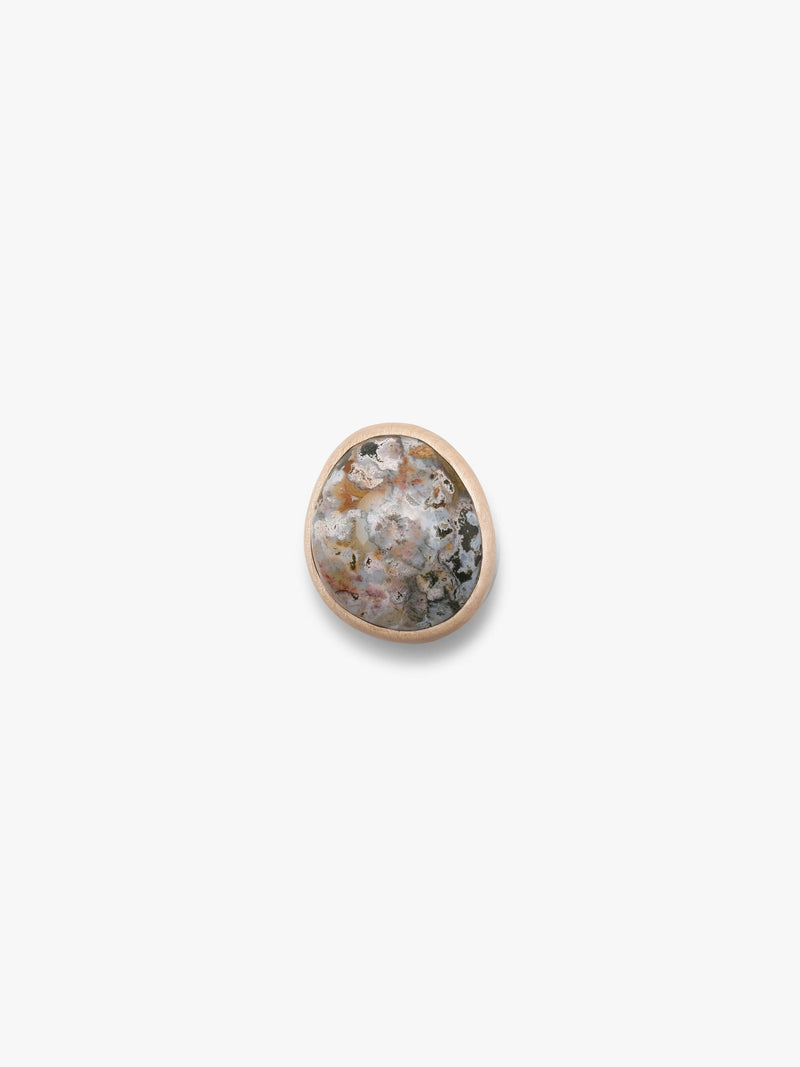 A large ring, with a marble stone top set into a light wood, with a light colored leather band. Displayed on a white background