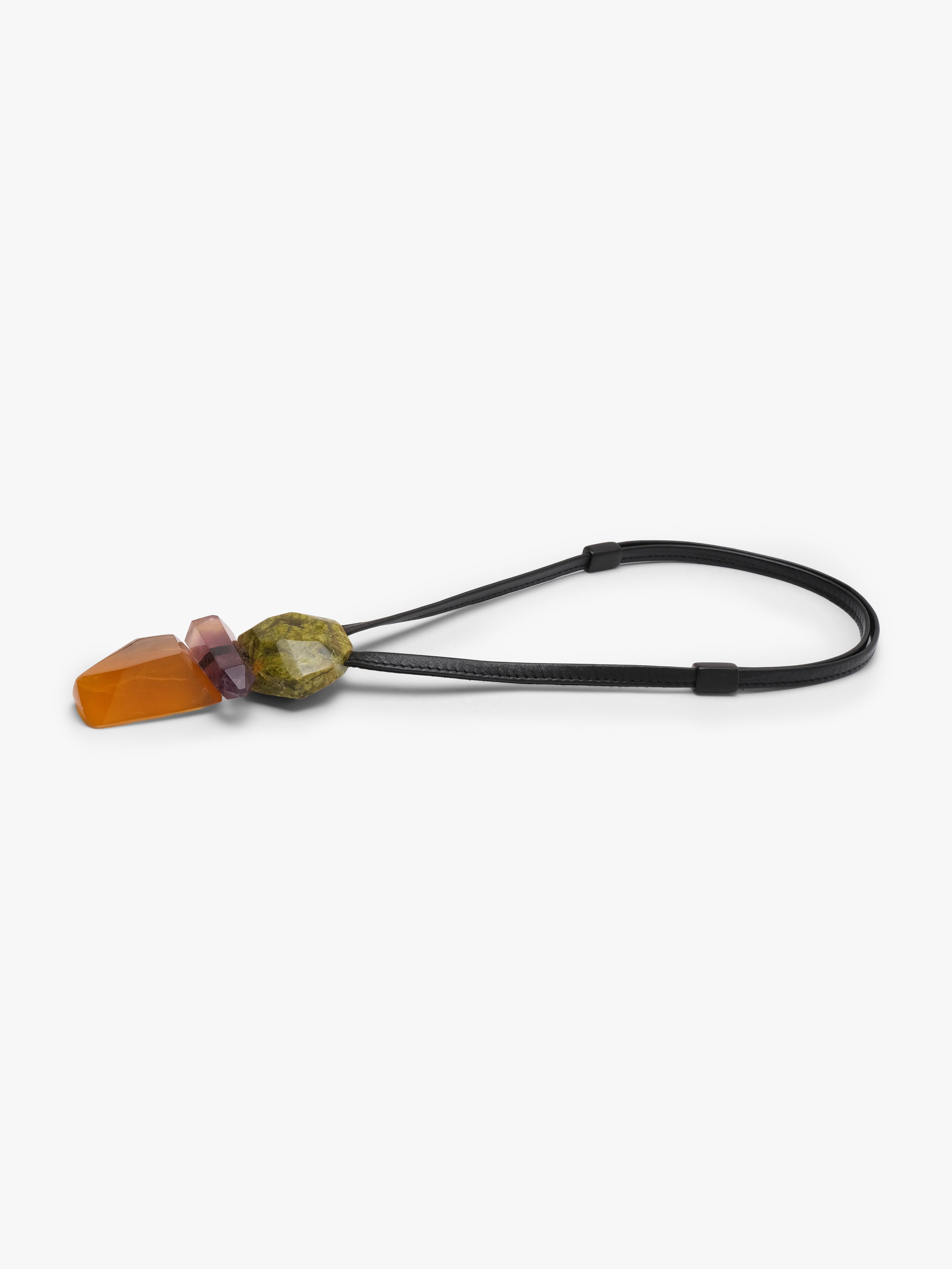 Pendan with a black leather cord and a cluster of natural stones in green, purple and orange. Displayed on a white background. 