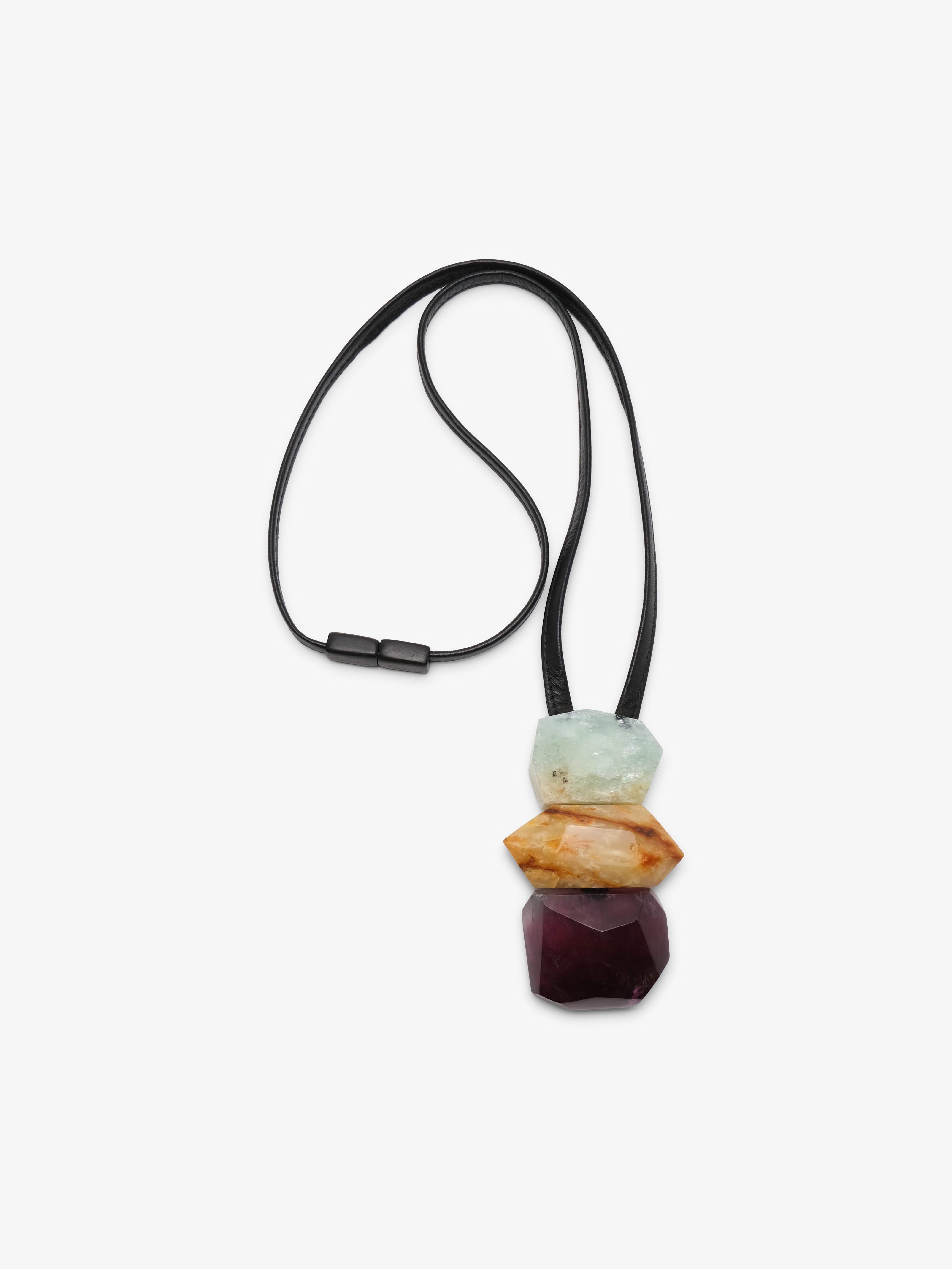 Black leather pendant with a cluster of natural stones in light blue, golden and purple colors. Displayed on a white background.