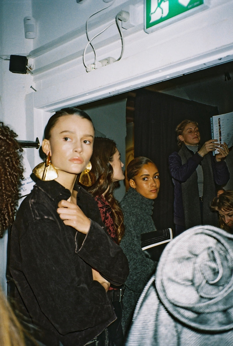 Women in a rooom, one wearing big gold earrings