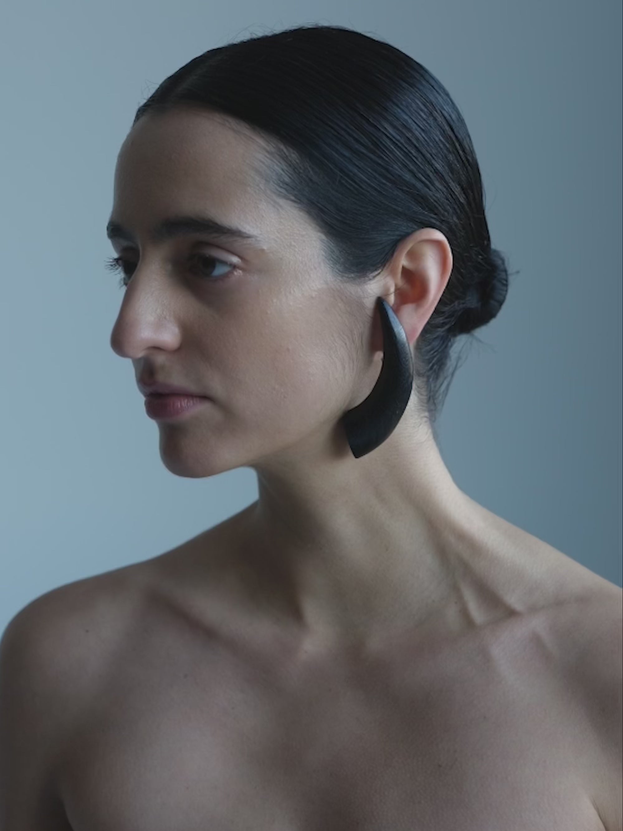 Woman wearing Black wooden earrings on a white background