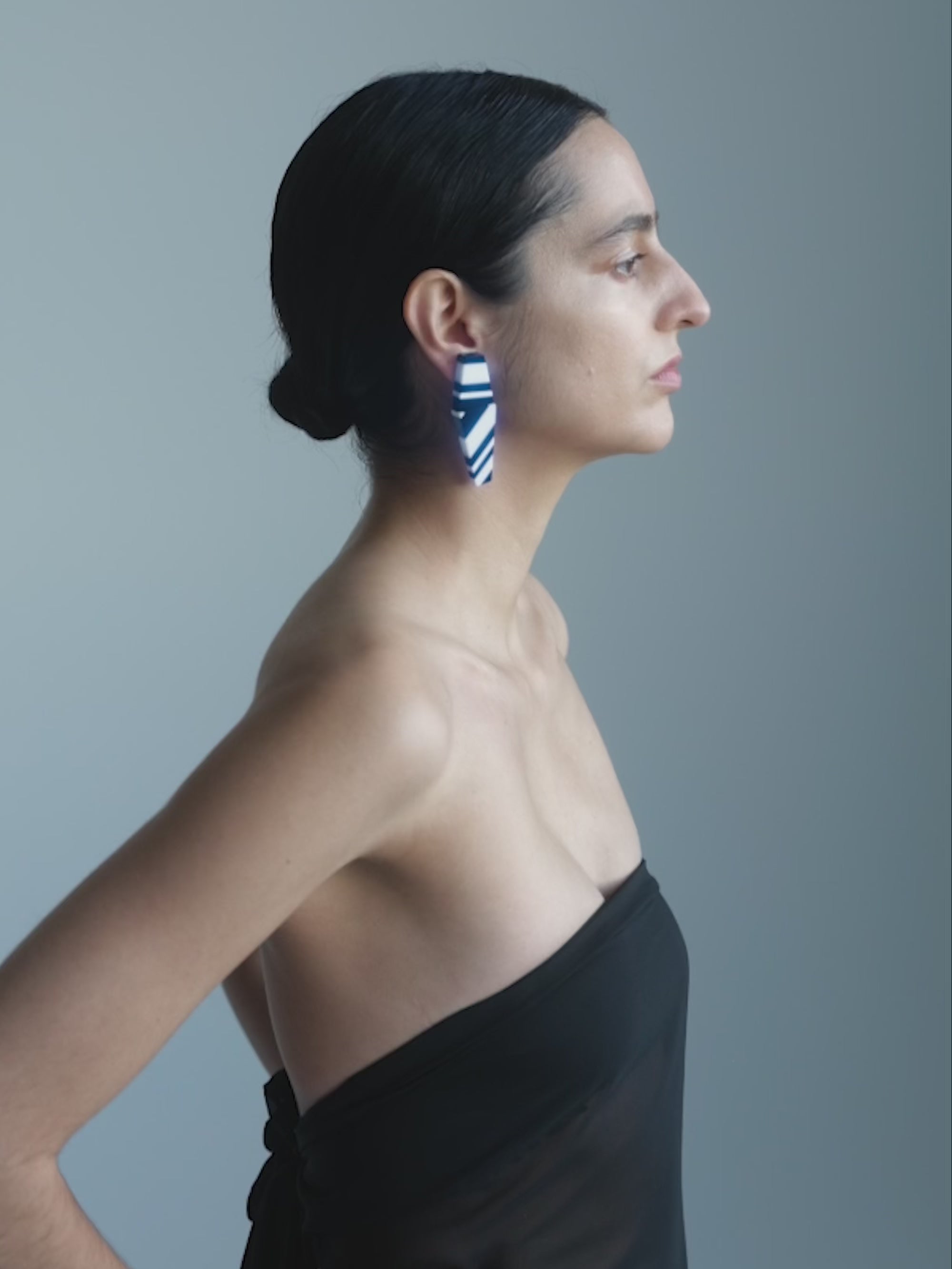 Woman wearing Black and white striped earrings s on a white background