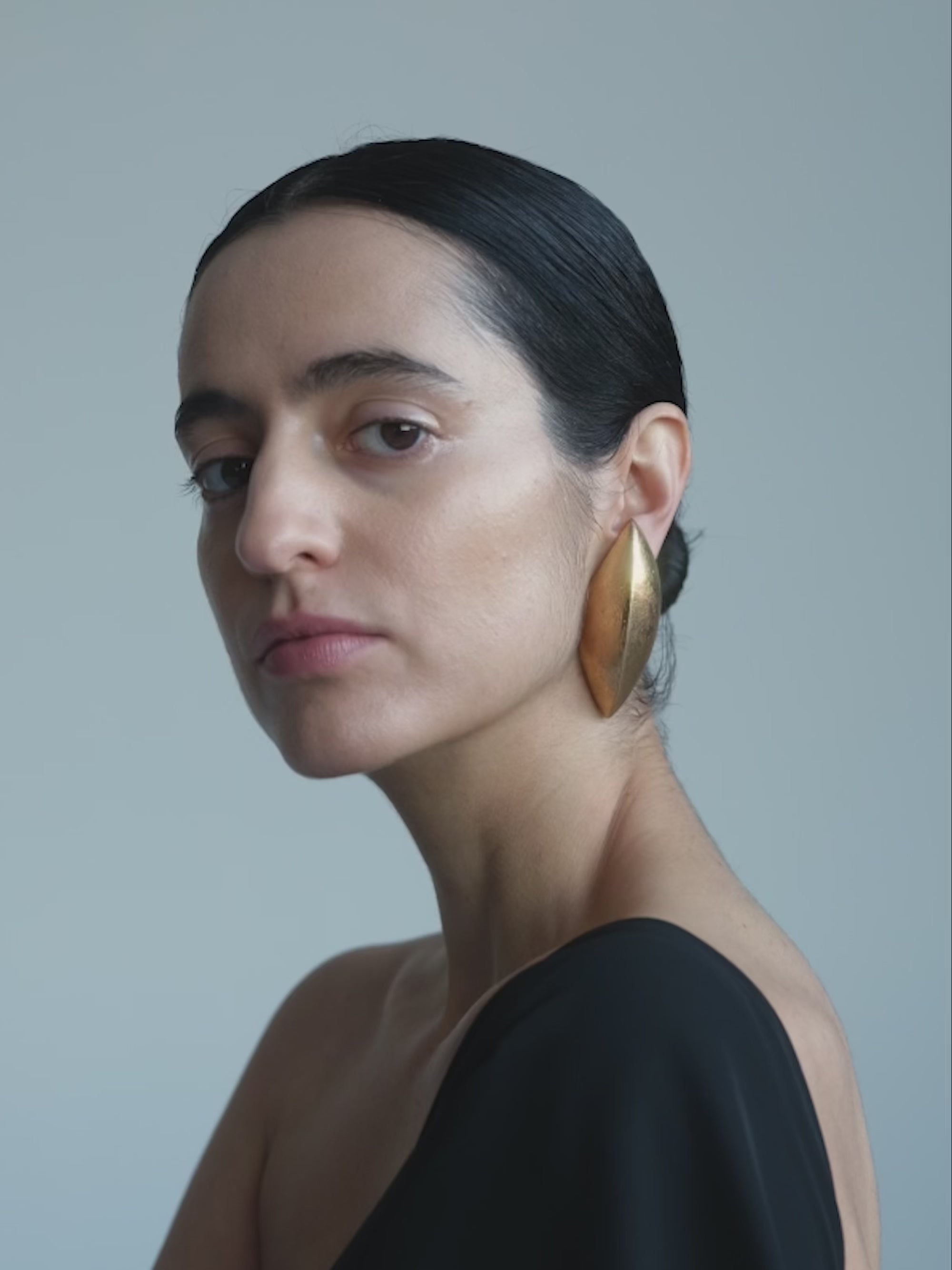 Woman wearing Gold earrings on a white background