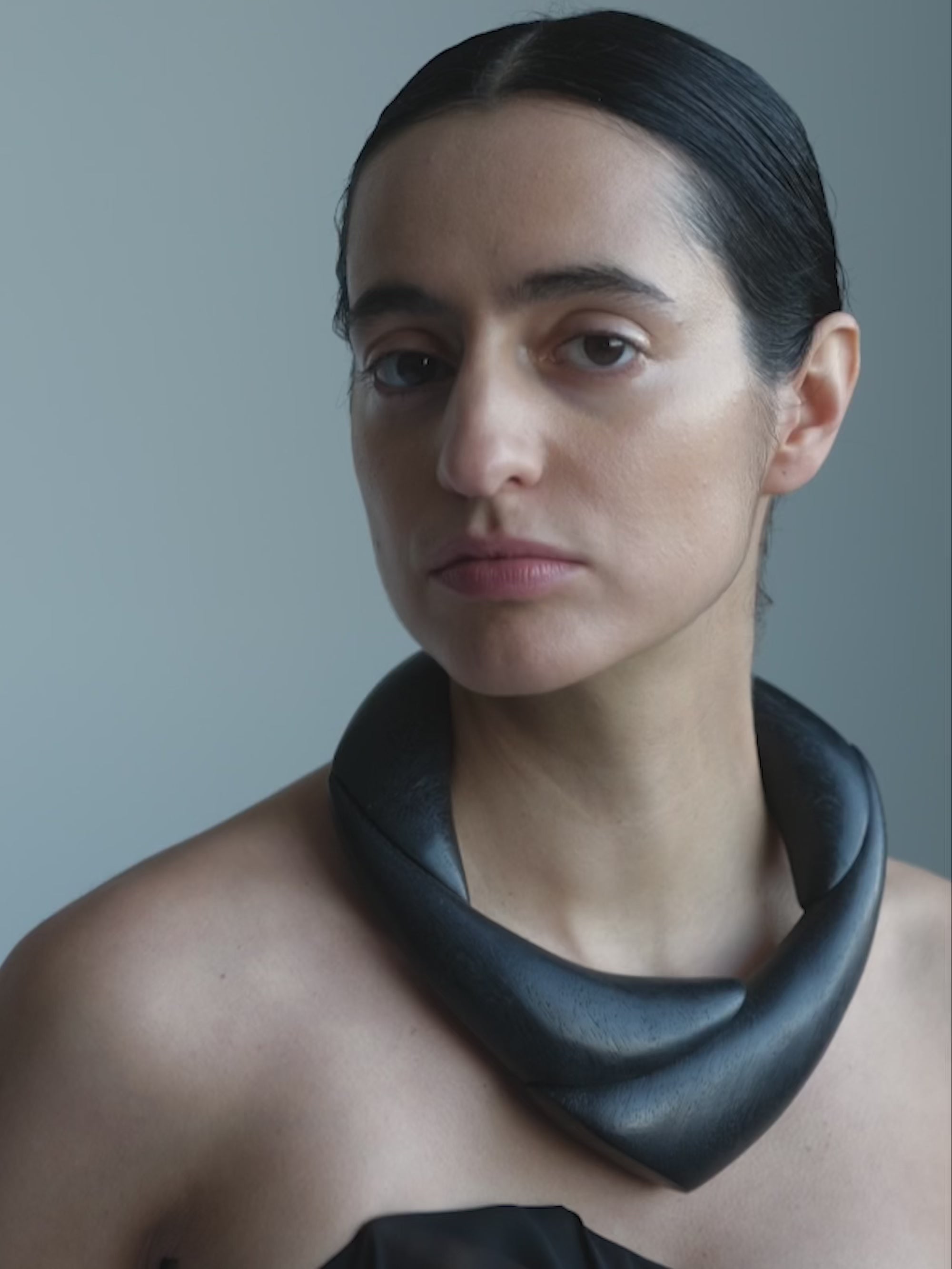Woman wearing a black wooden necklace on a white background