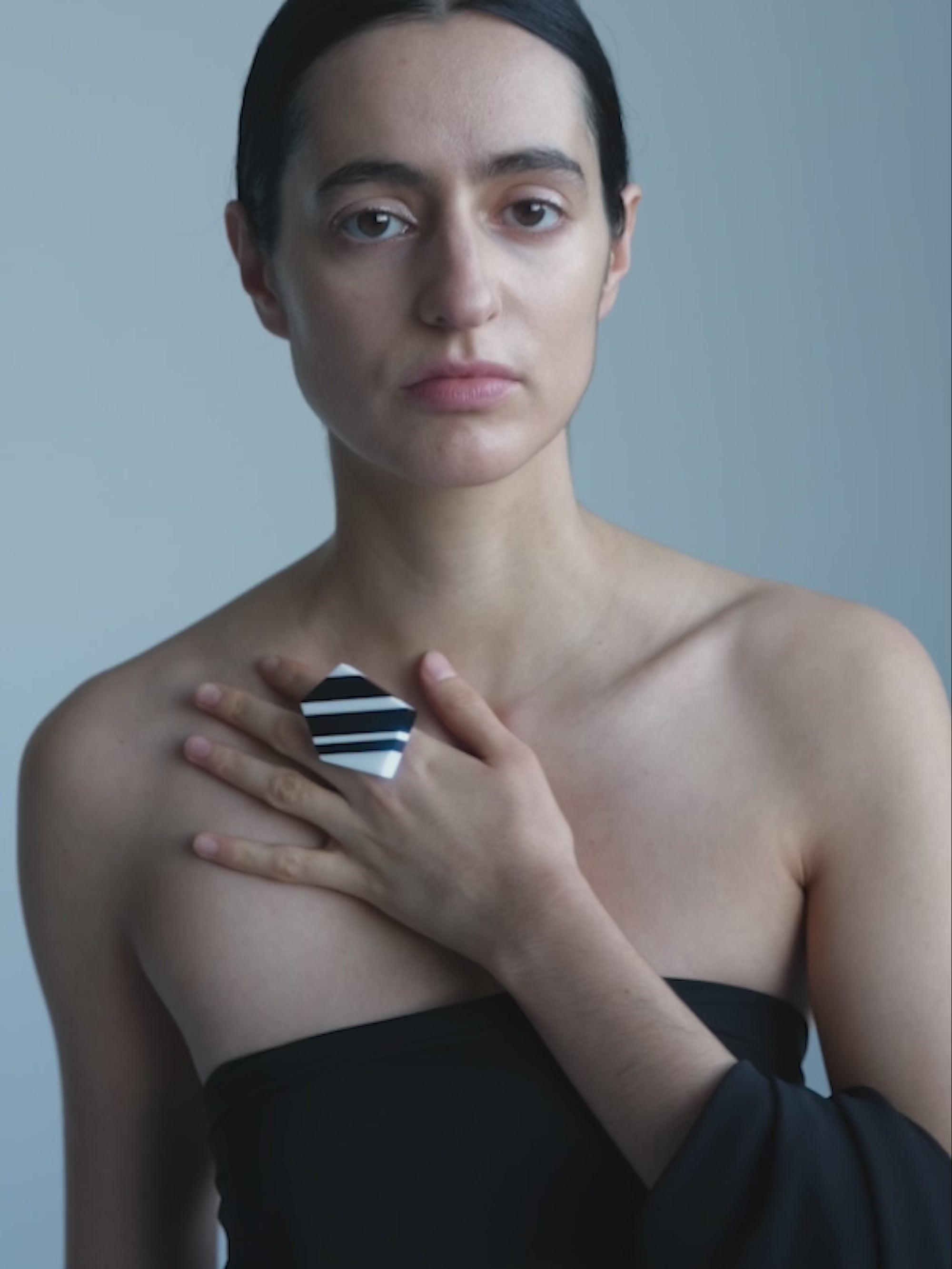 Woman wearing a Black and white ring  on a white background