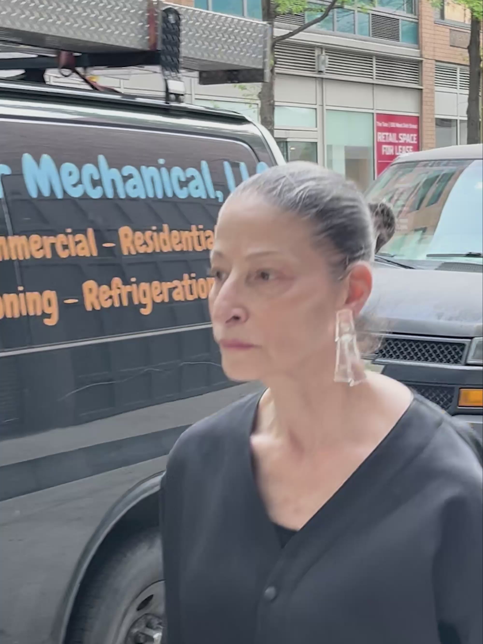 woman walking around wearing transparent earrings
