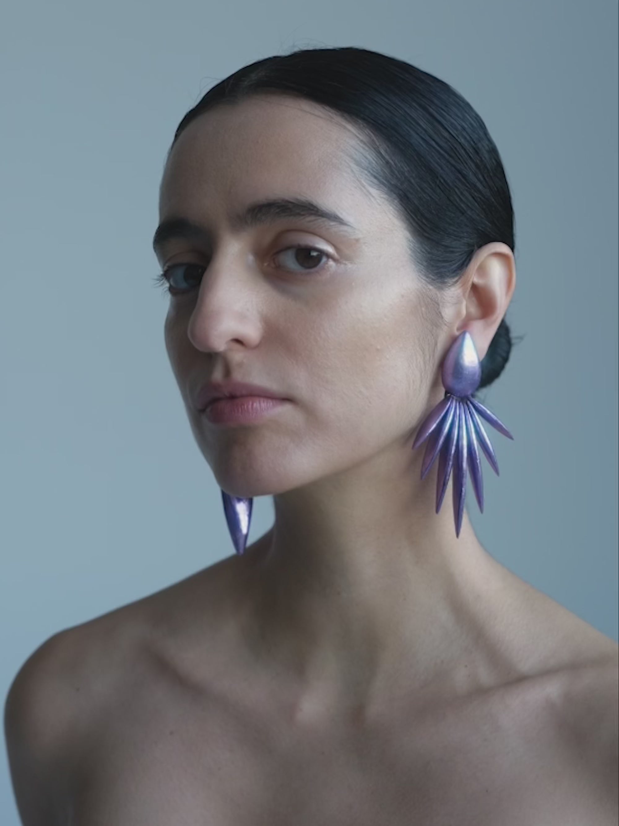 Woman wearing Purple earrings on a white background