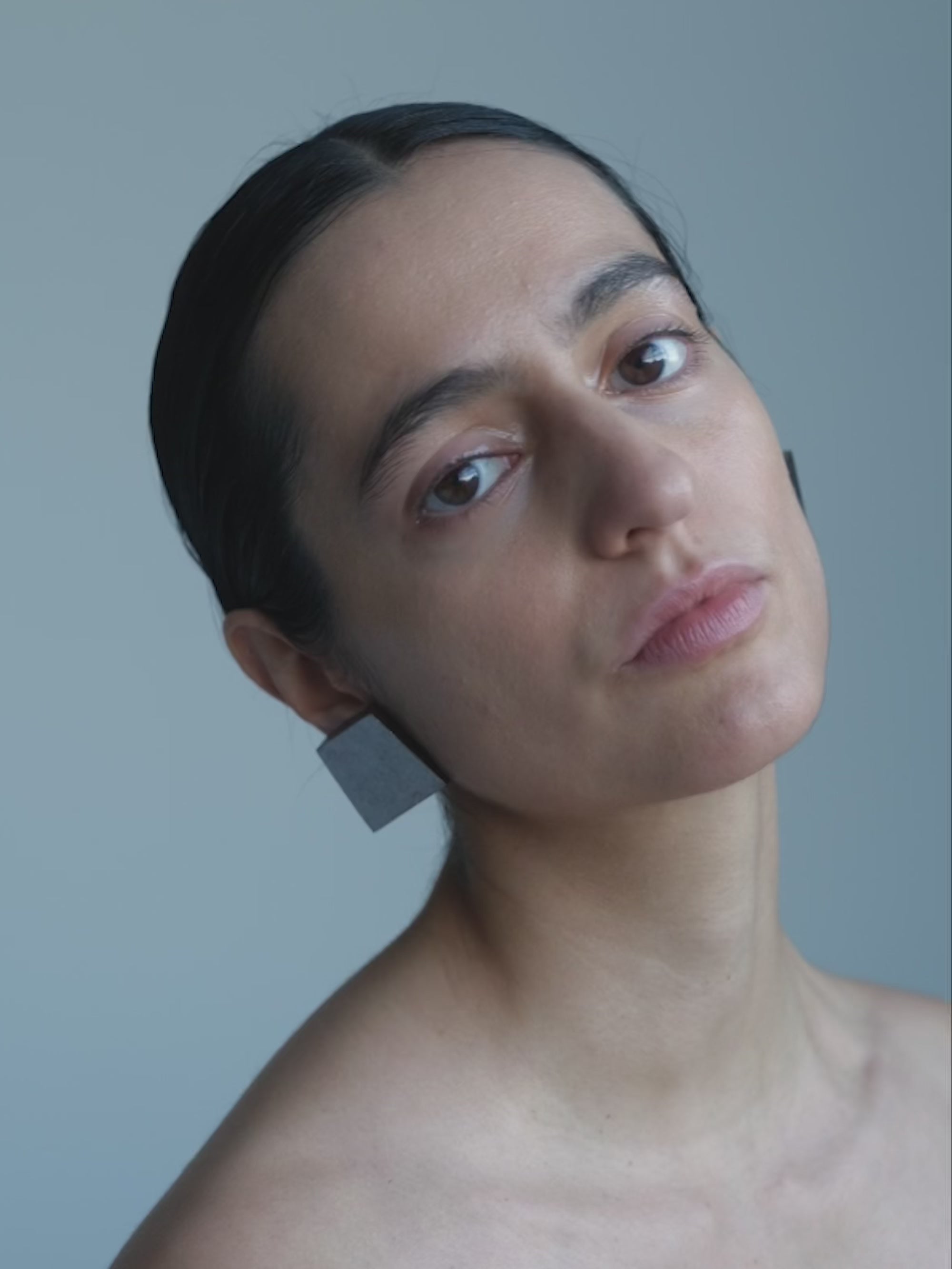 Woman wearing Silver foil square earrings on a white background