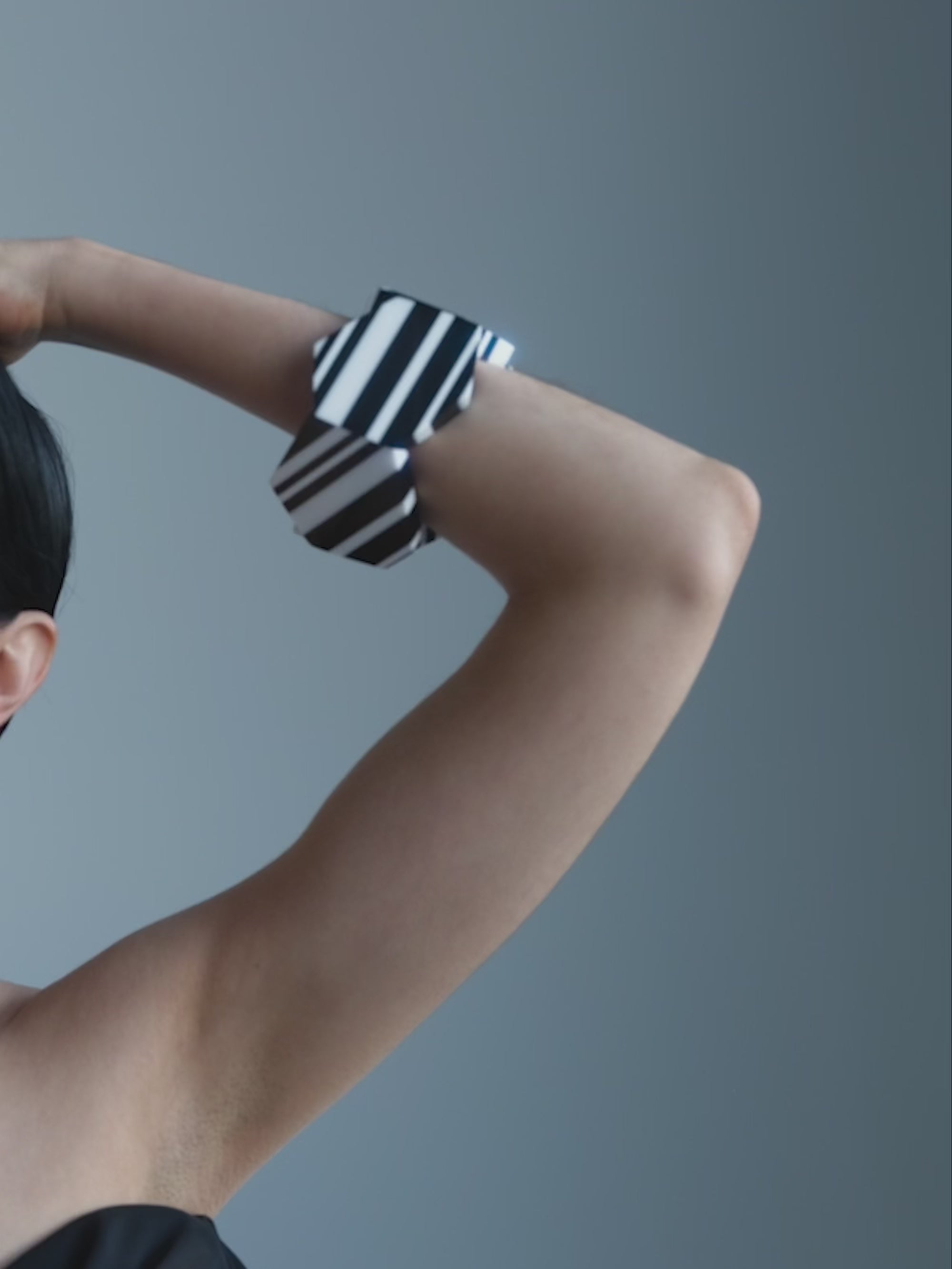 Woman wearing a black and white bracelet on a white background