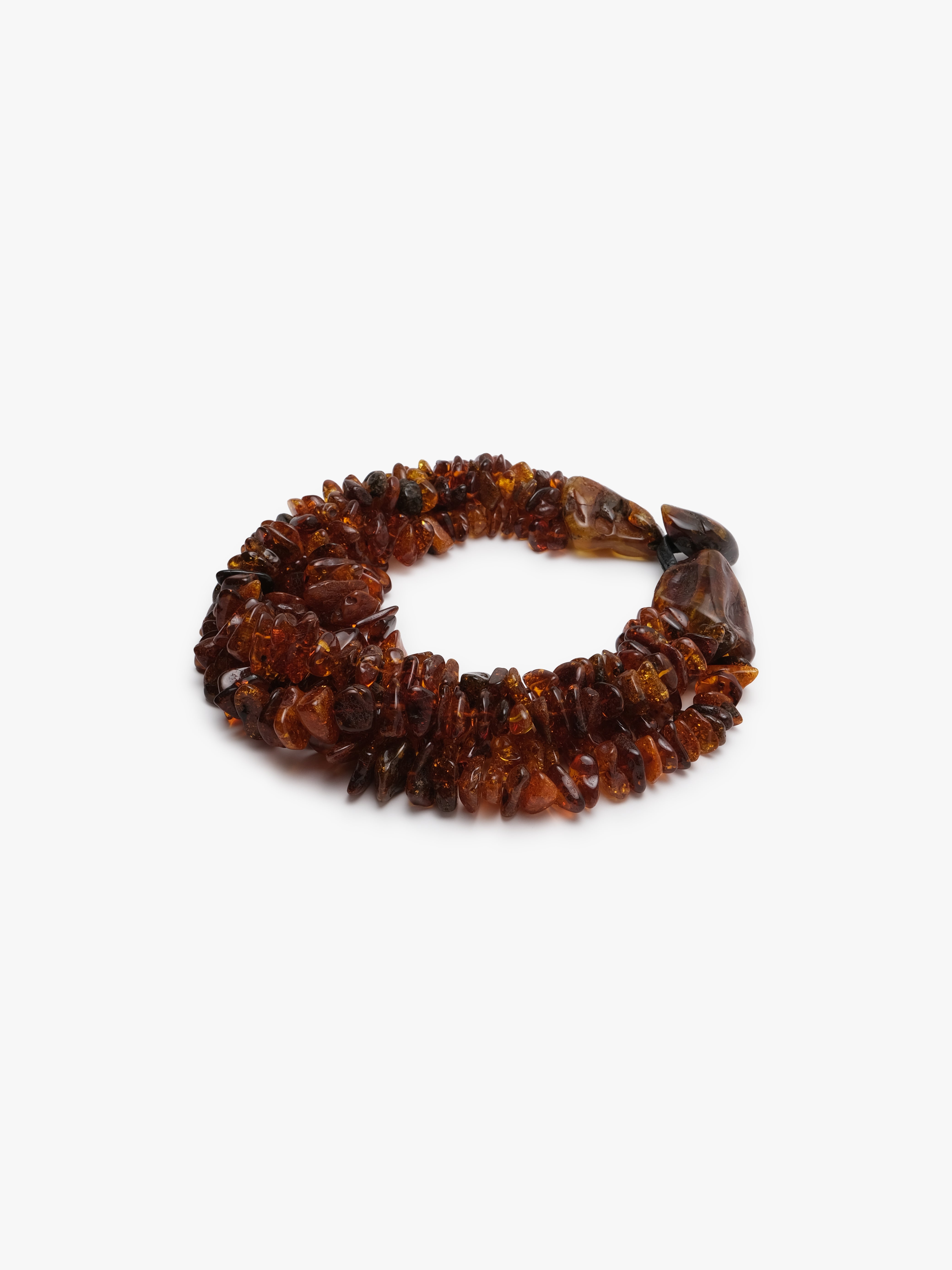 A multi-strand bracelet made of polished amber-colored stone chips, arranged in a circle on a plain white background.