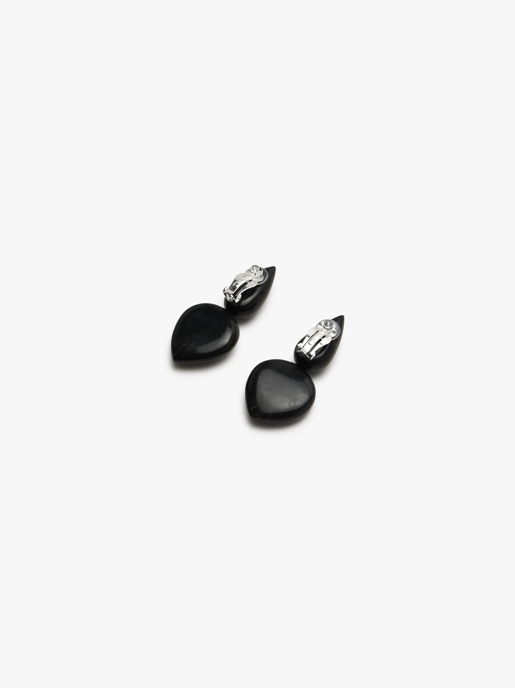 Pair of earrings with black and blue stones on a white background