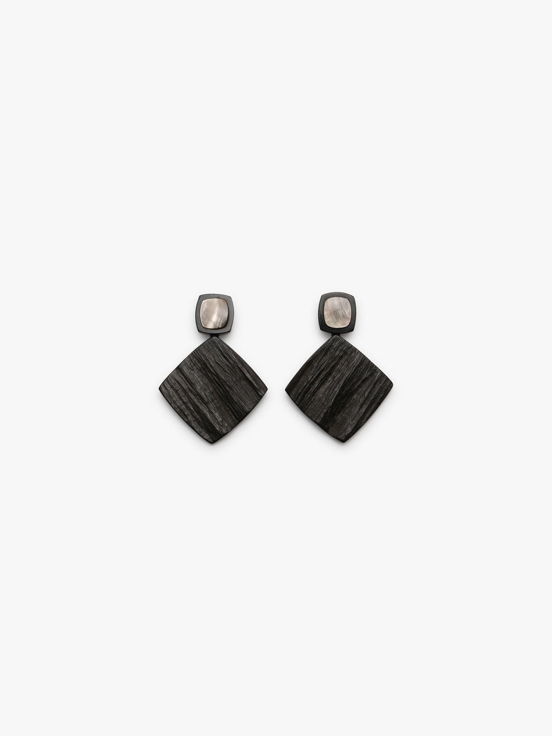 Geometrical earrings with brown and shell details on a white background