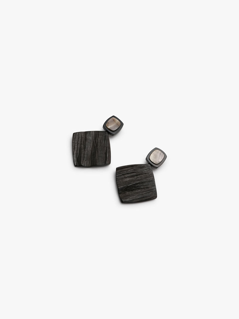 Geometrical earrings with brown and shell details on a white background